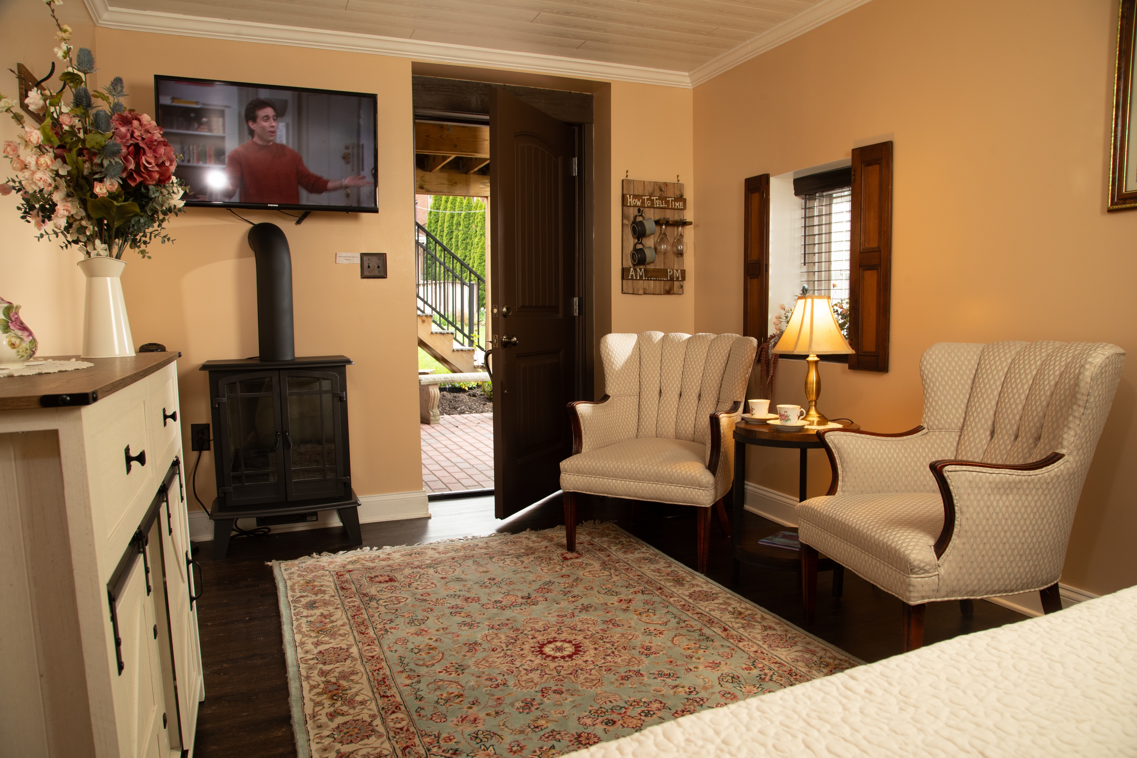 Cozy living space with two armchairs, a TV, and an entrance door leading outside.