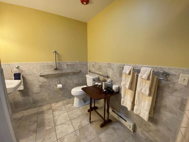 The Swope Suite toilet with grab bars, table for toiletries, and roll under sink.