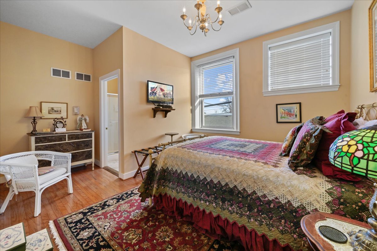 The Southern Spice Chamber features a queen size metal bed, 2 chairs, TV and a dresser.