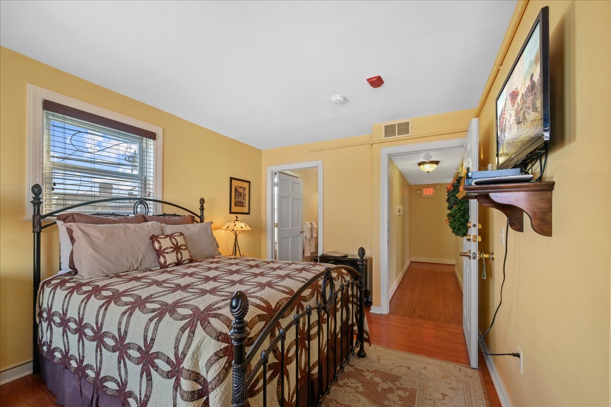 Jacob's Den Chamber features a queen-size metal bed, dresser, and electric stove.