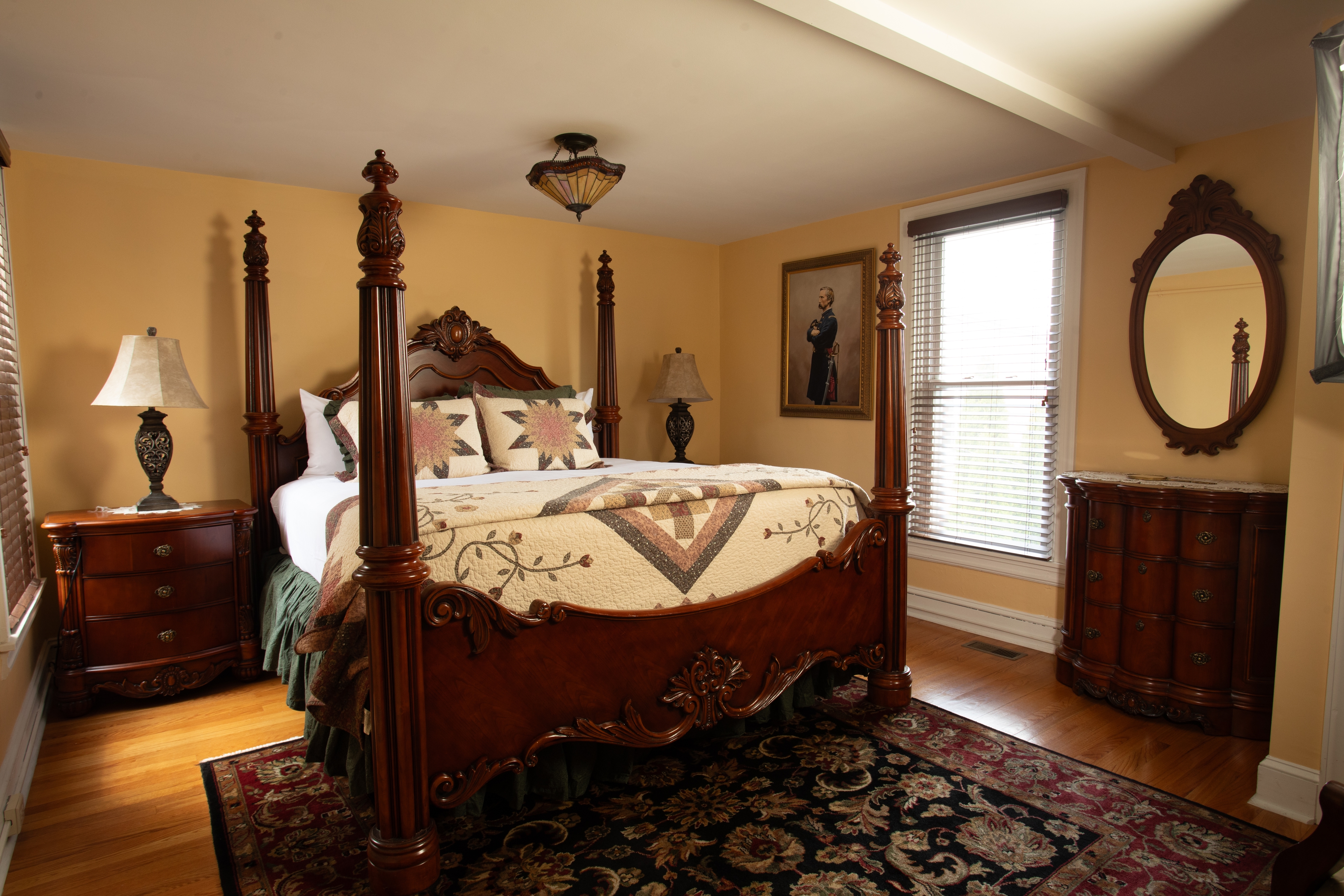 The Chamberlain bedroom featuring a four-poster bed, wooden furniture, and warm yellow walls.