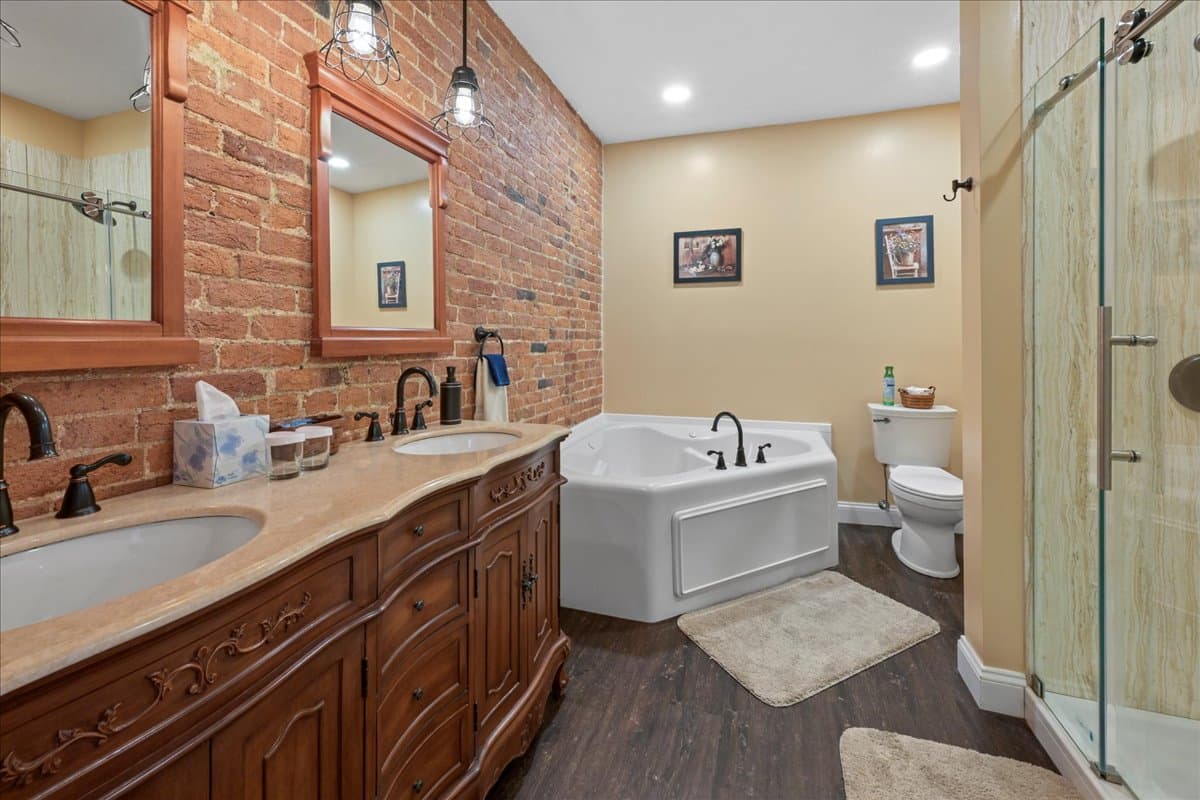 The Garden Chamber bathroom includes a jetted tub, a vanity with his and her sinks, toilet, and a dual headed shower.
