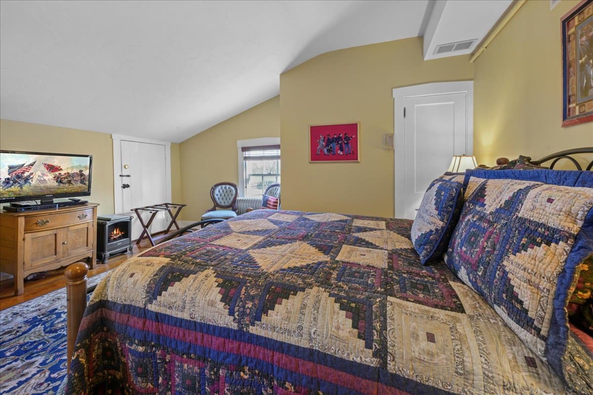 The Lt. Pohlman Chamber features a queen-size metal bed, dresser, TV, and 2 chairs.