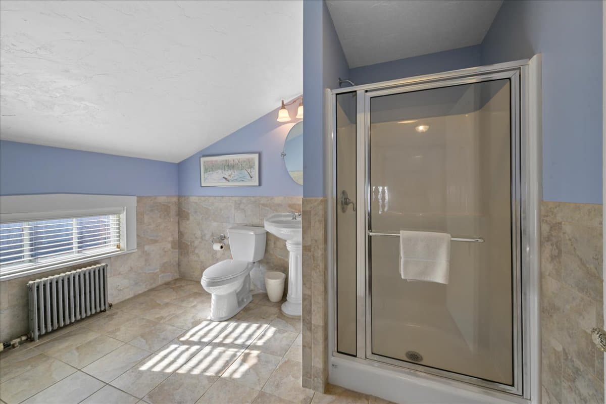 The Major General Meade Suite bathroom features a walk in shower, pedestal sink, toilet, and ceramic tile flooring.