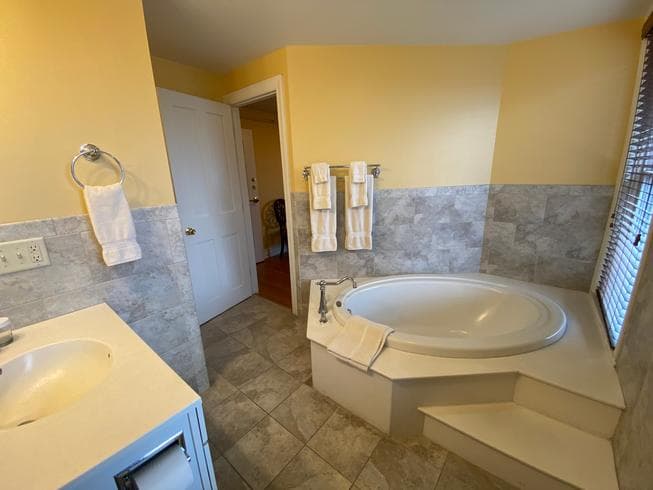 The Colonel Chamberlain Suite bathroom features a soaking tub and tile flooring.