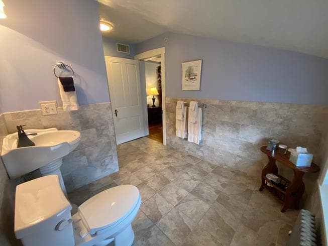 The Major General Meade Suite bathroom features a walk in shower, pedestal sink, toilet, ceramic tile flooring.