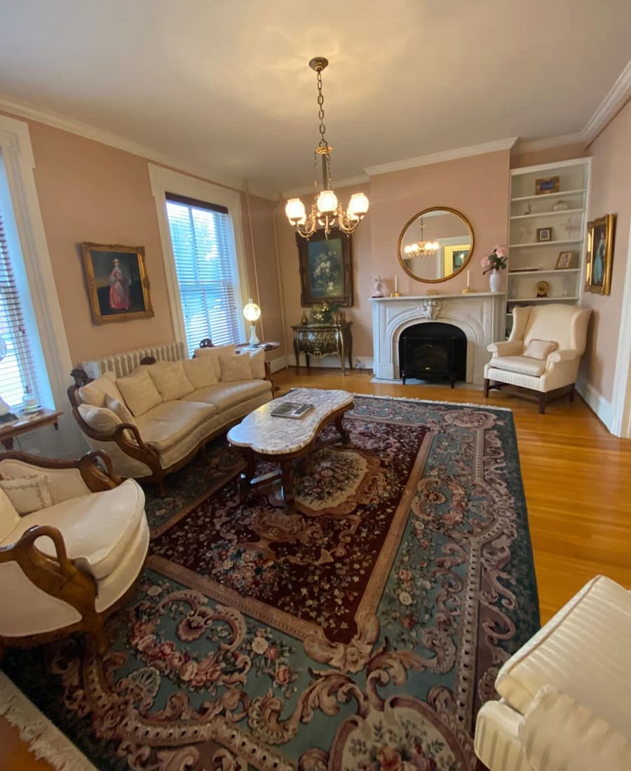 A cozy living room featuring elegant furniture, a chandelier, and a decorative rug.