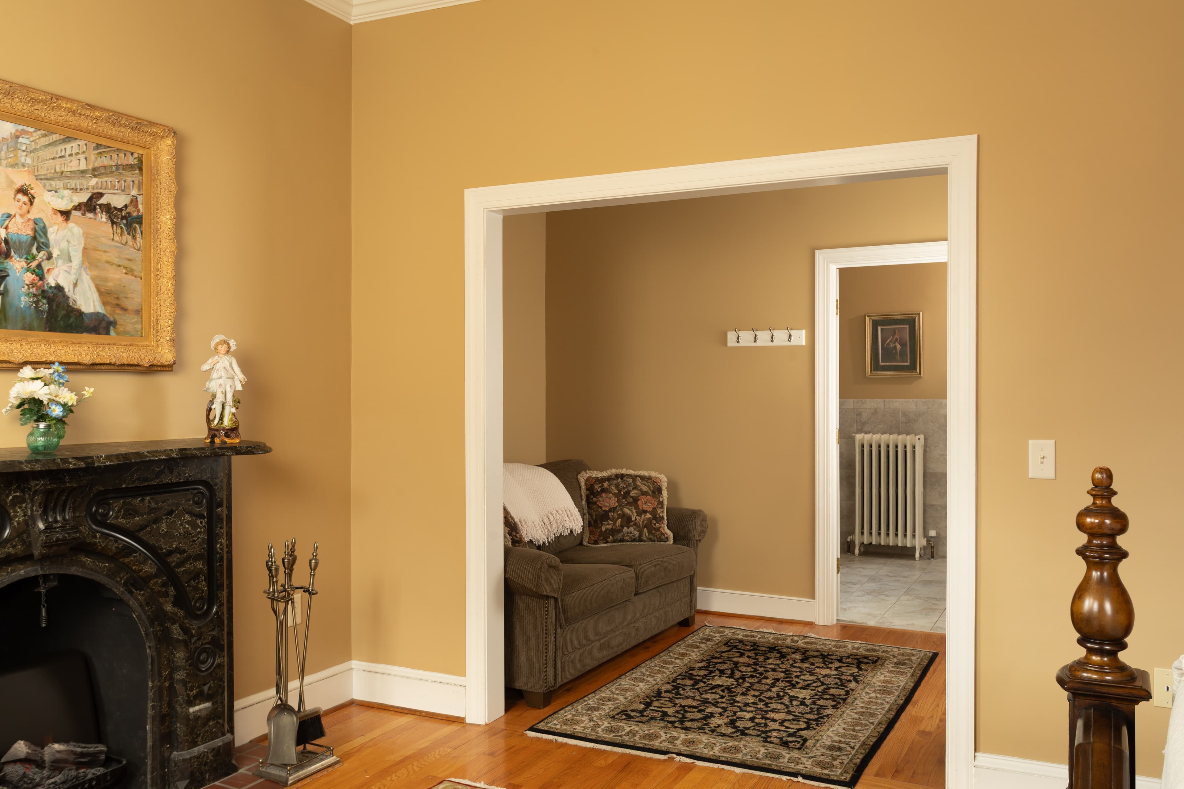 An elegantly decorated living room featuring a fireplace, a couch, and doorways leading to adjacent rooms.