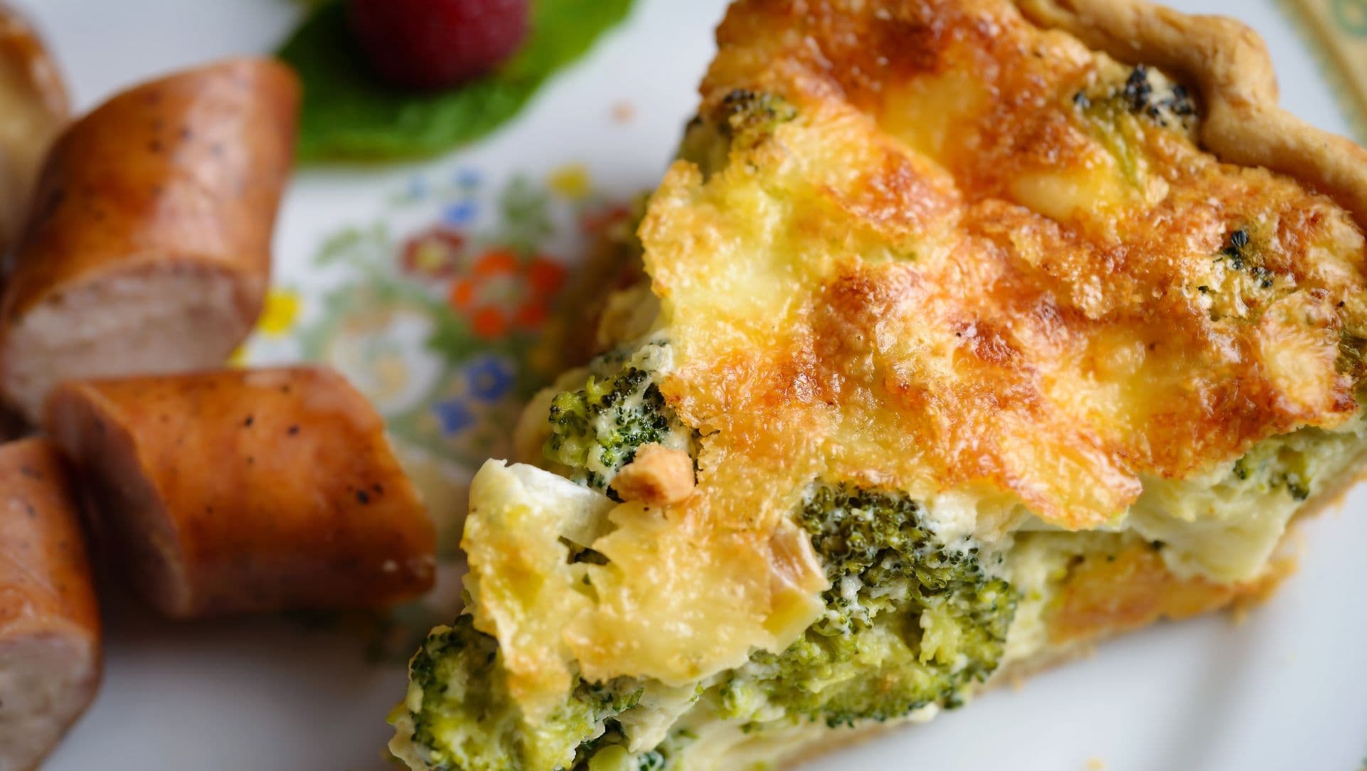 Broccoli cheddar quiche plated with chicken sausage