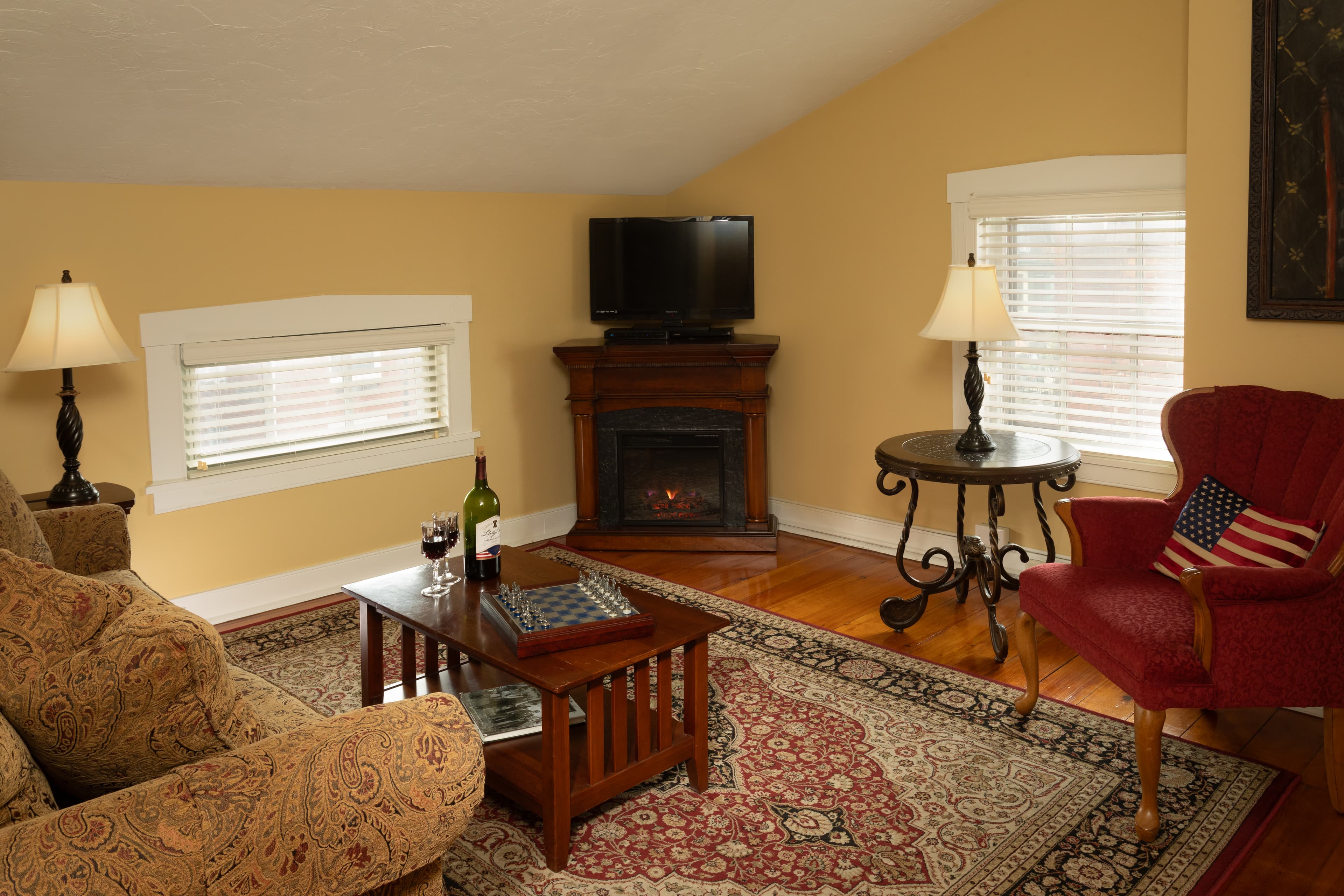 Cozy living room with a sofa, armchair, coffee table, and a fireplace.