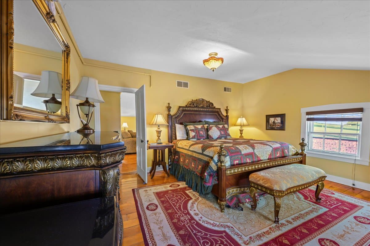 A cozy bedroom featuring a lavish bed, decorative lamps, and a rich color scheme.