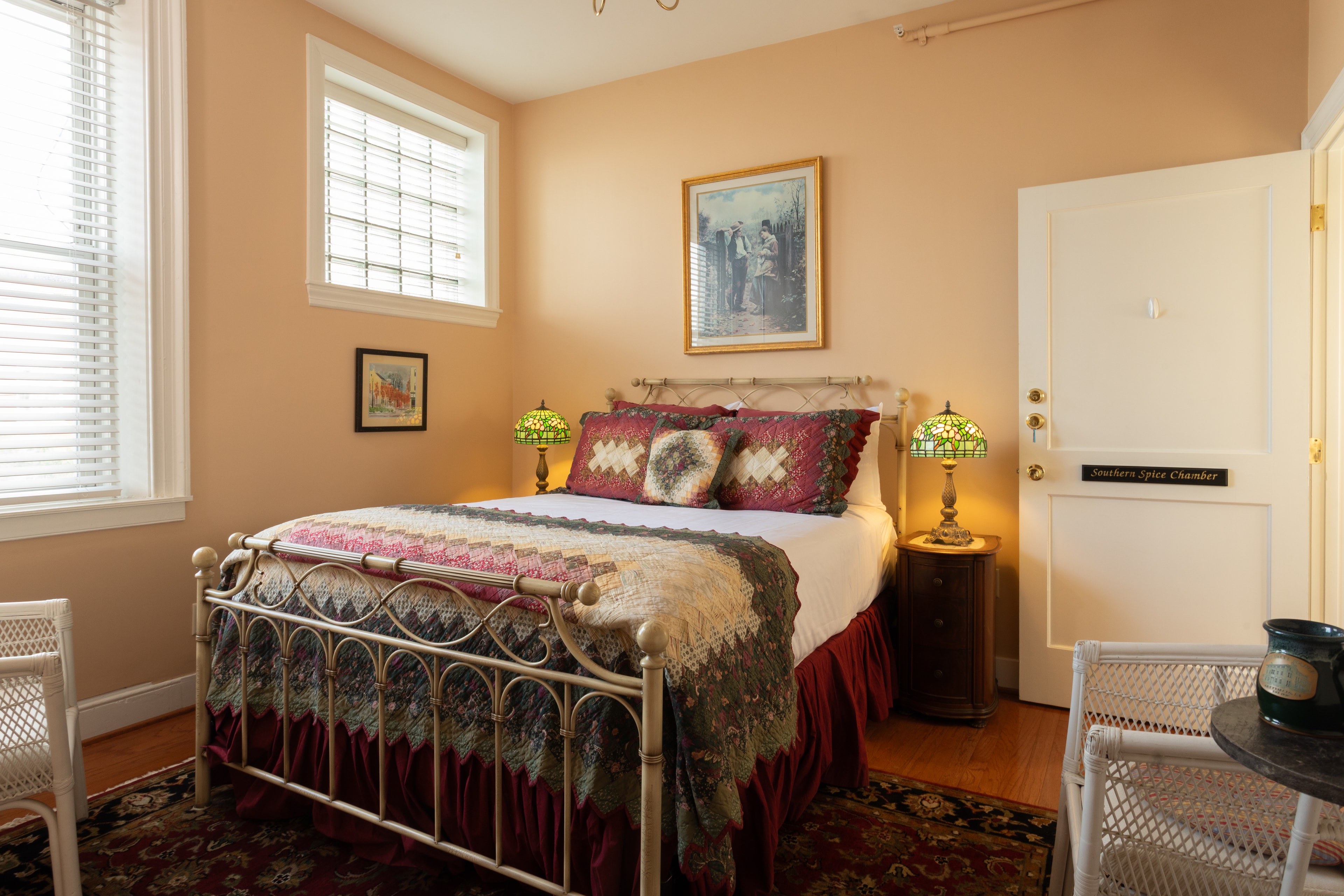 Cozy bedroom featuring a metal bed frame, colorful bedding, and vintage decor with a warm color palette.