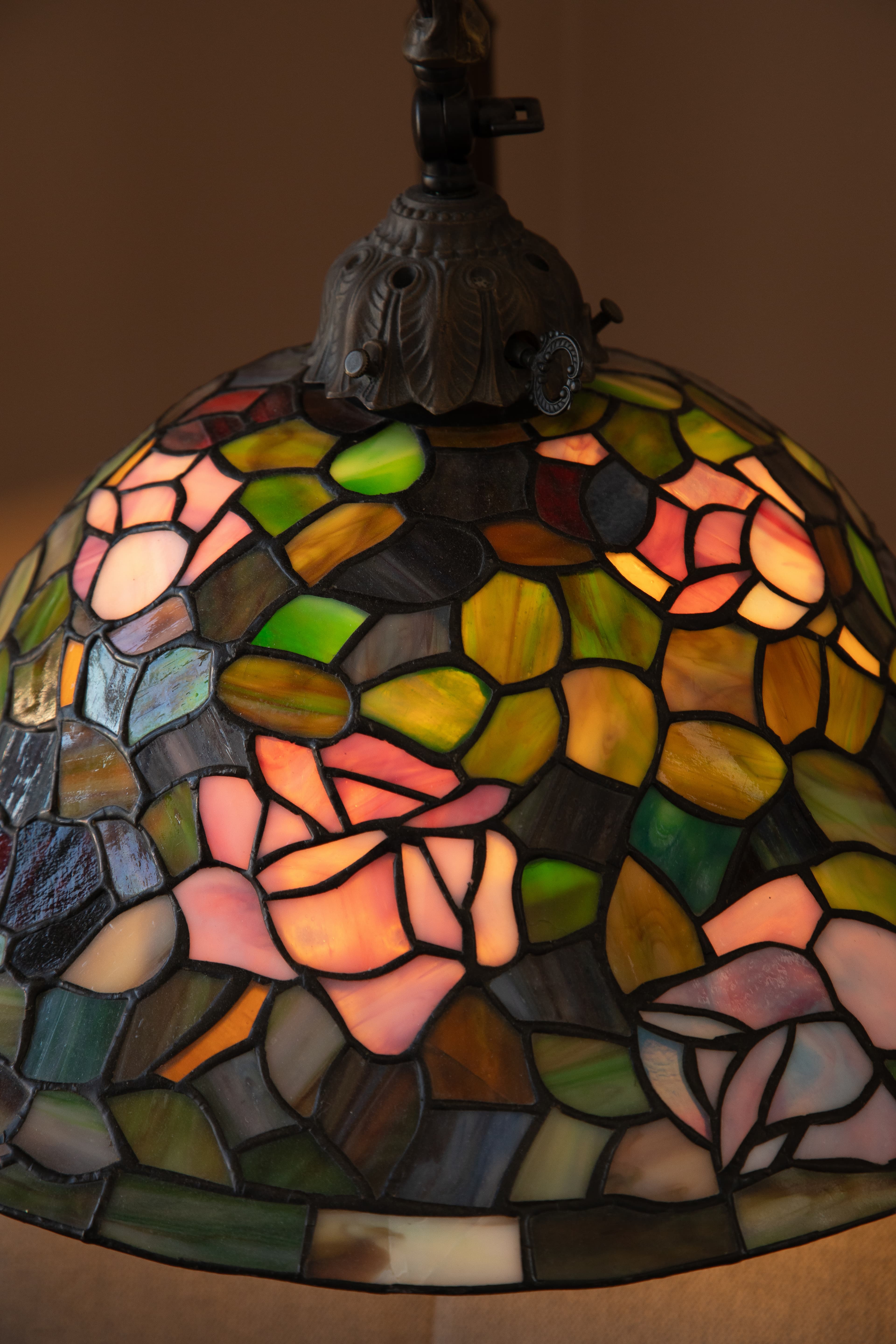 A close-up of a stained glass lampshade featuring floral designs in vibrant colors.
