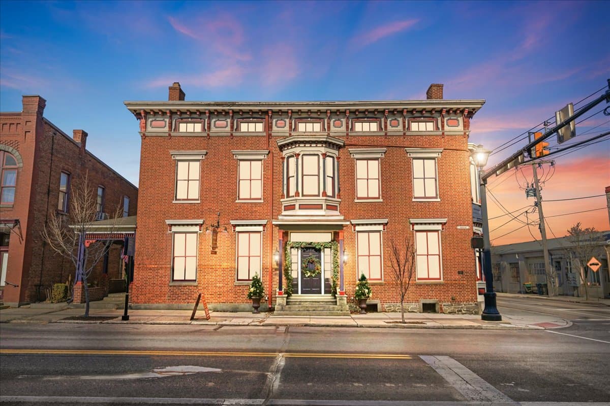 Bricked historic building with decorative windows at sunset.