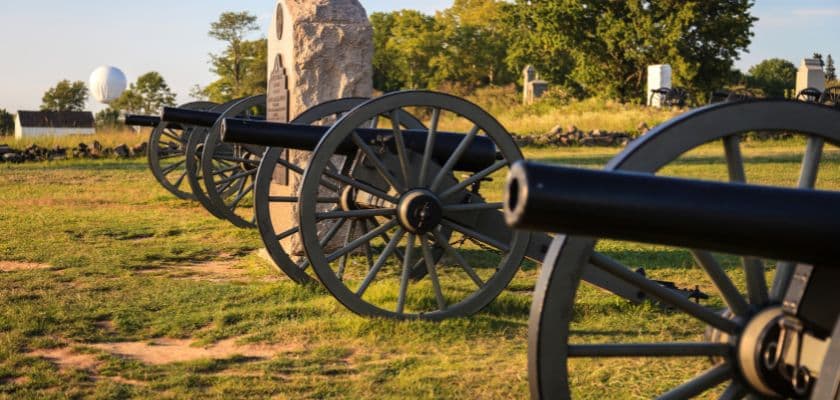 A row of historical cannons on a grassy field.