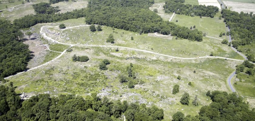 Aerial view of Little Round Top, showing rocky slopes, open fields, winding paths, and surrounding woods at Gettysburg Battlefield.